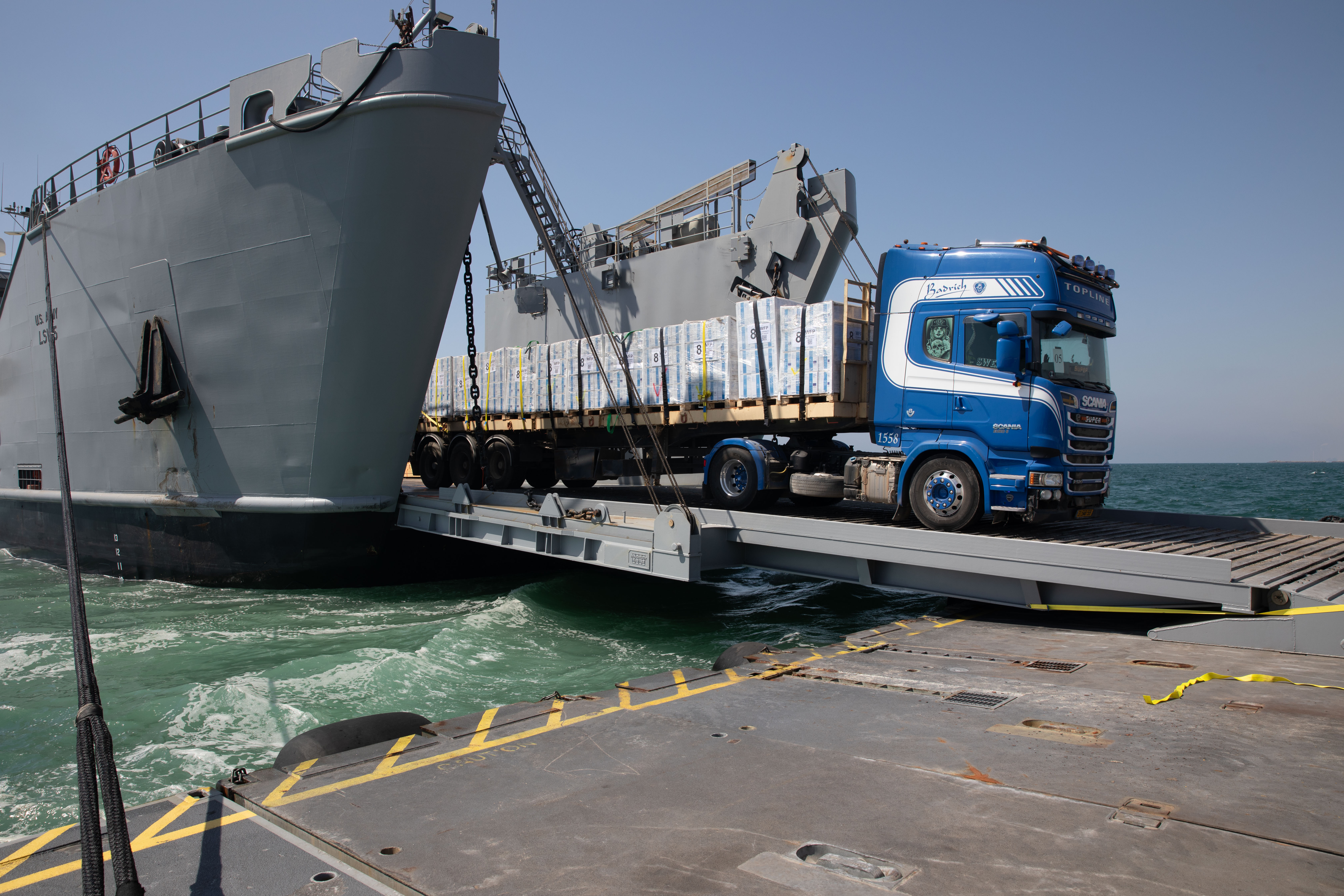 A DoD-contracted driver transports humanitarian aid across the temporary pier and onto the beach in Gaza 