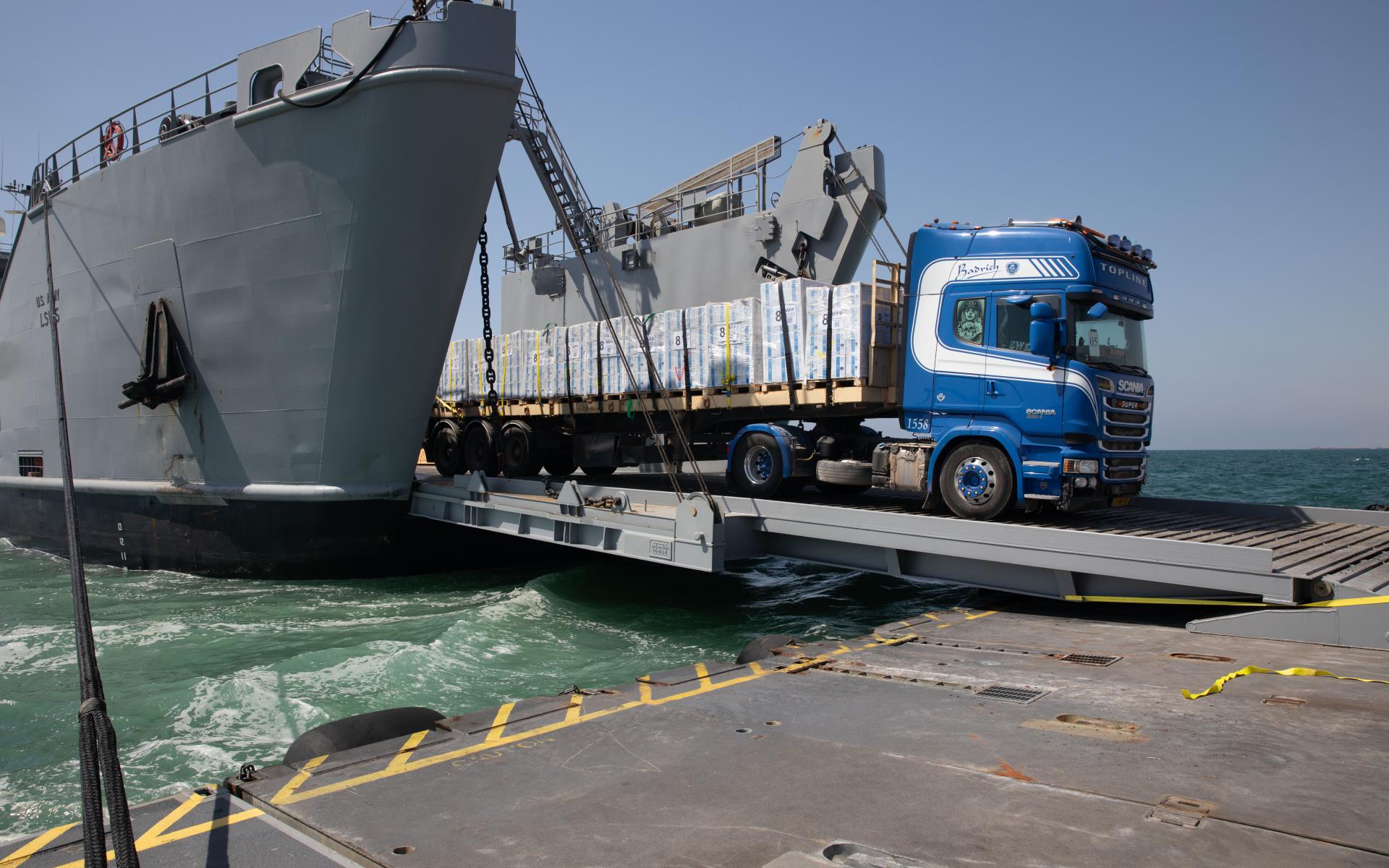 A DoD-contracted driver transports humanitarian aid across the temporary pier and onto the beach in Gaza 